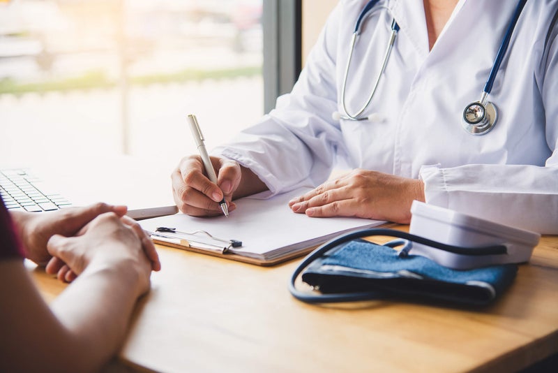 doctor taking notes during consultation